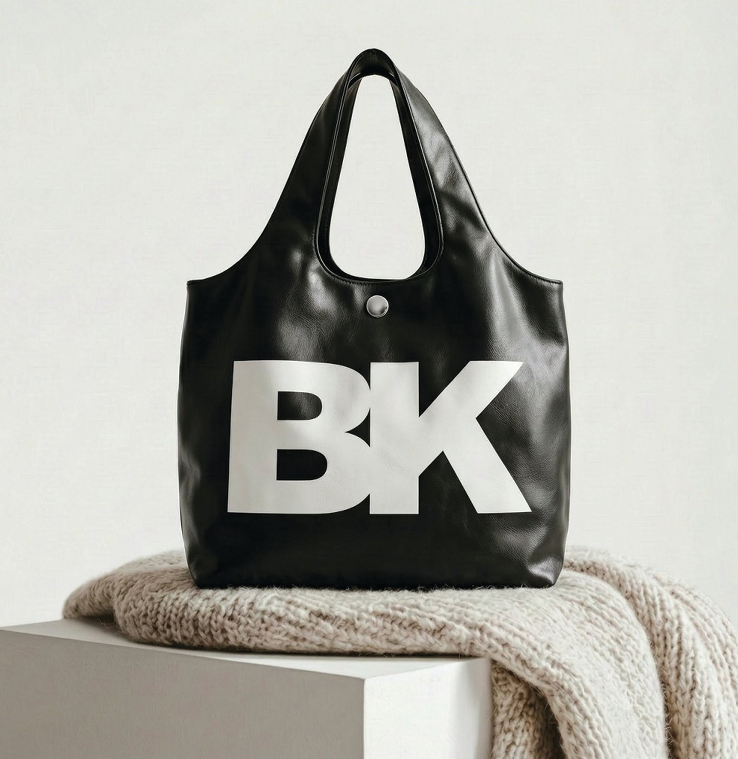 Black tote bag with 'BK' logo on a light surface