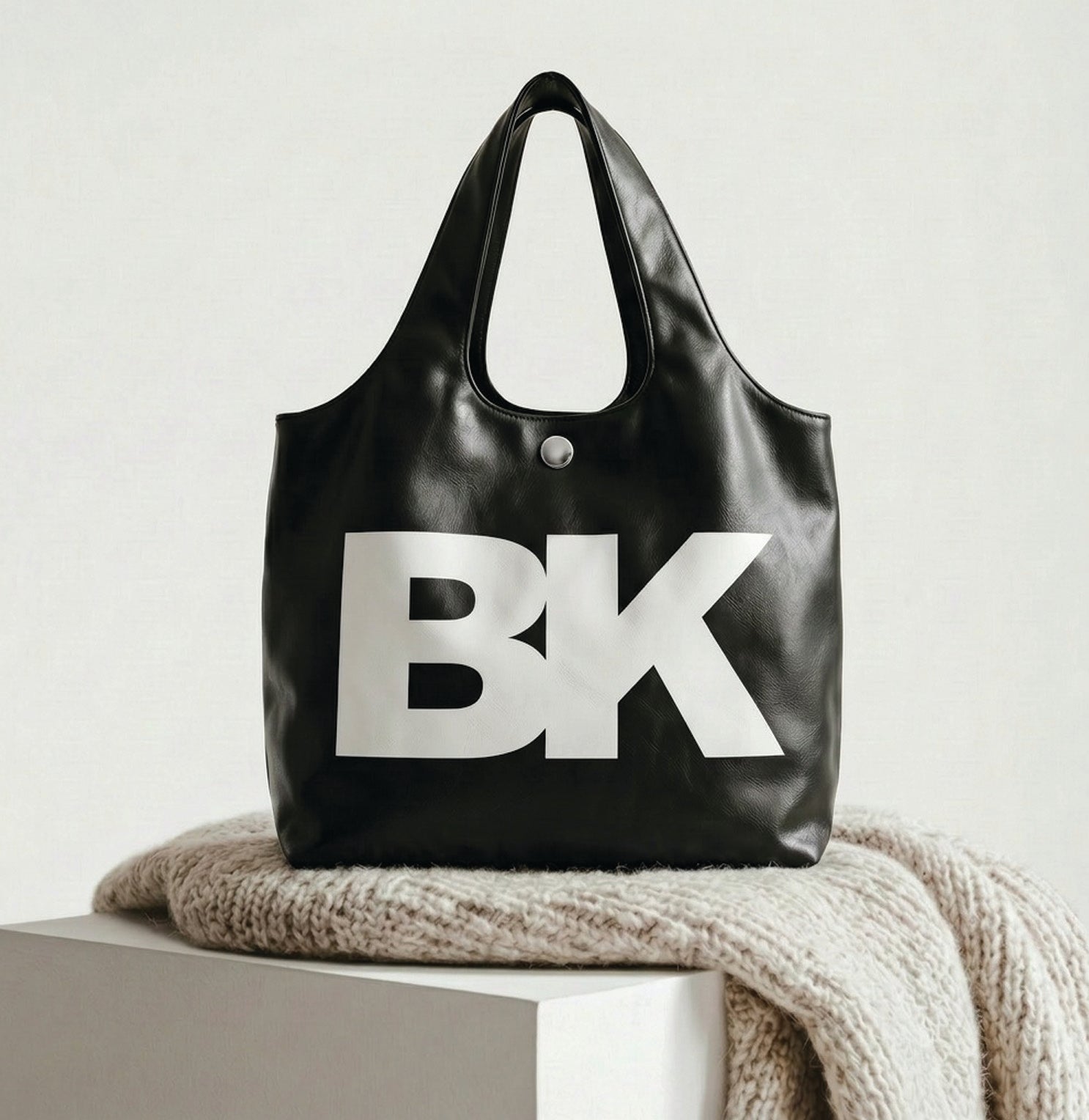 Black tote bag with 'BK' logo on a light surface